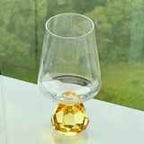 Copo Taça com base esfera ambar na bancada