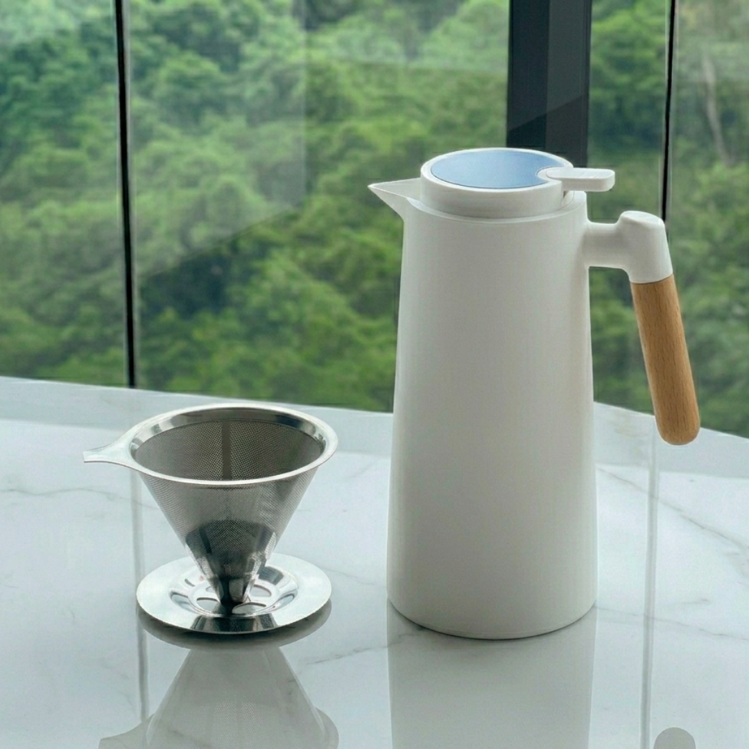 Jarra térmica branca com filtro de café e alça de madeira em ambiente com vista