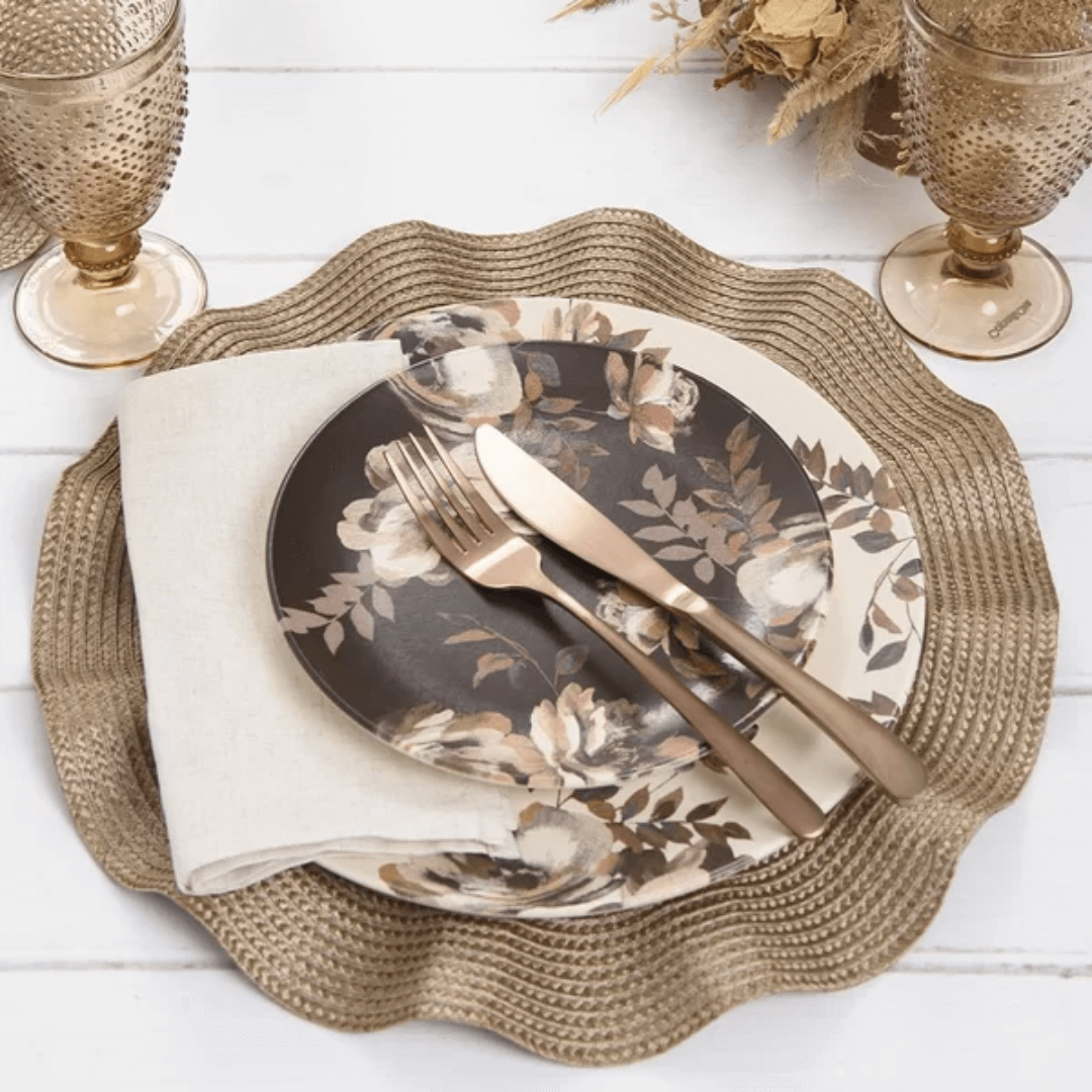 Mesa posta com americano redondo, prato estampado e talheres dourados