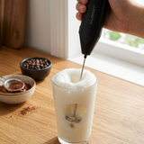 Batedor de leite criando espuma em bebida com chocolate em pó