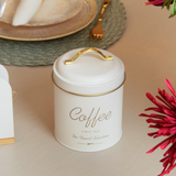 Detalhe da alça e tampa do pote de café branco com acabamento dourado