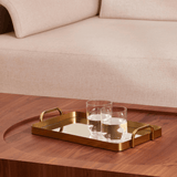 bandeja dourado com vidro espelho e copos de whisky no centro da sala de estar