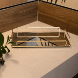 bandeja com alças douradas e vidro com espelho na bancada do banheiro