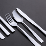 garfo e faca de sobremesa com colher de café na mesa e bancada