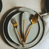 garfo faca e colher em cima do prato raso cinza