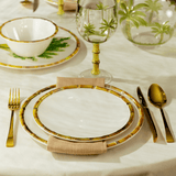 prato branco com bambu e talheres dourados na mesa posta