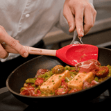 Frigideira para frango grelhados com espátula vermelha de silicone e madeira