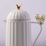 garrada branca com tampa de rosca e passaro dourado