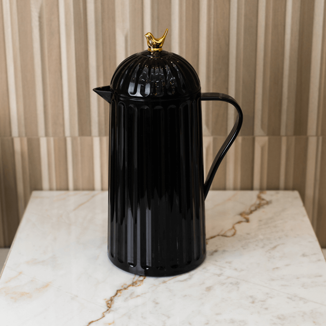 garrafa preta com alça e passaro dourada na tampa