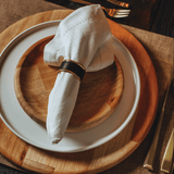 Pratos de bambu natural com guardanapo de pano branco e anél porta guardanapo preto