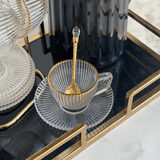 xícara com filete dourado na borda com colher dourada