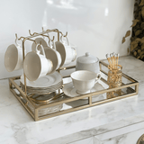 bancada de cantinho do cafe com xicaras, açucareiro e porta colheres para café dourado