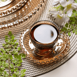 Xícara de café sobre americano fresno em mesa decorada com plantas