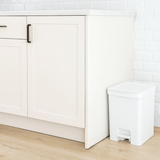 lixeira branca com pedal e tampa no chão da cozinha