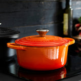 Panela sobre cooktop preto. Perfeita para preparos lentos e receitas gourmet, com tampa ajustada e design clássico que destaca sofisticação e alto desempenho na cozinha.