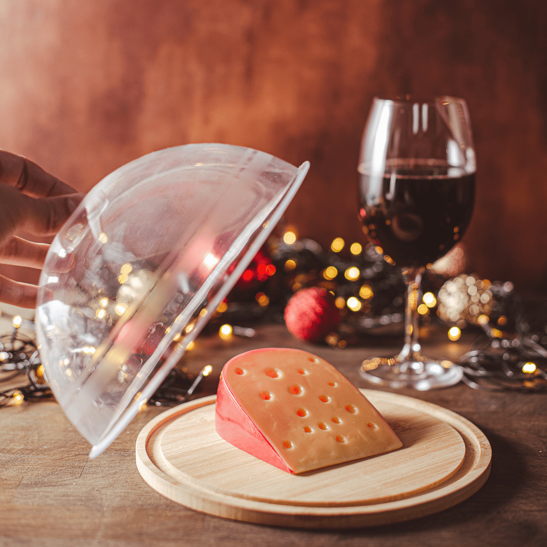 Queijeira redondo com queijo parmessão e taça de vinho em uma mesa de reveillon