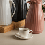 xicara branca e garrafa de café rosa