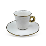 Detalhe da alça dourada e borda em relevo da xícara de café