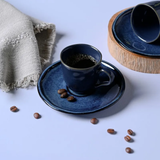 Xícara de café fumegante com grãos de café e pano de linho