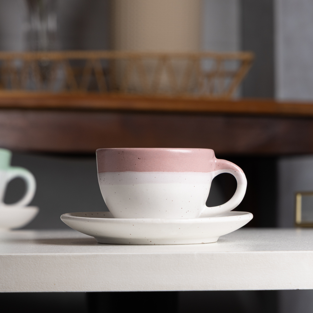 xicara de cafe com pires ombré rosa sobre prateleira decorada