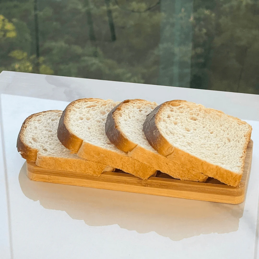 Bandeja de bambu retangular com fatias de pão integral