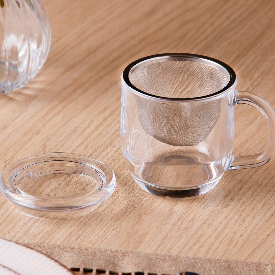 Caneca vidro com infusor removível e tampa preta em primeiro plano