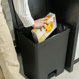 Colocando lixo na lixeira na cozinha