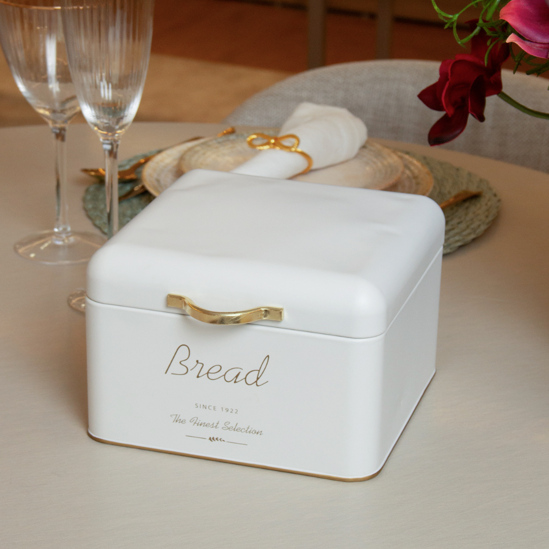 Porta pão branco com alça dourada em mesa de jantar elegante