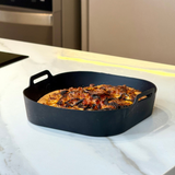 Forma silicone air fryer com frango assado dourado em bancada branca