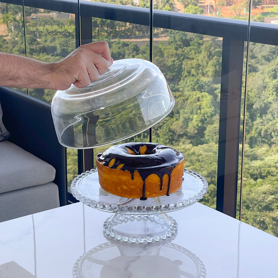 Cúpula de cristal sendo colocada sobre boleira com molheira vidro