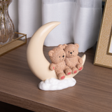 Figura decorativa ursos na lua em resina sobre móvel de madeira