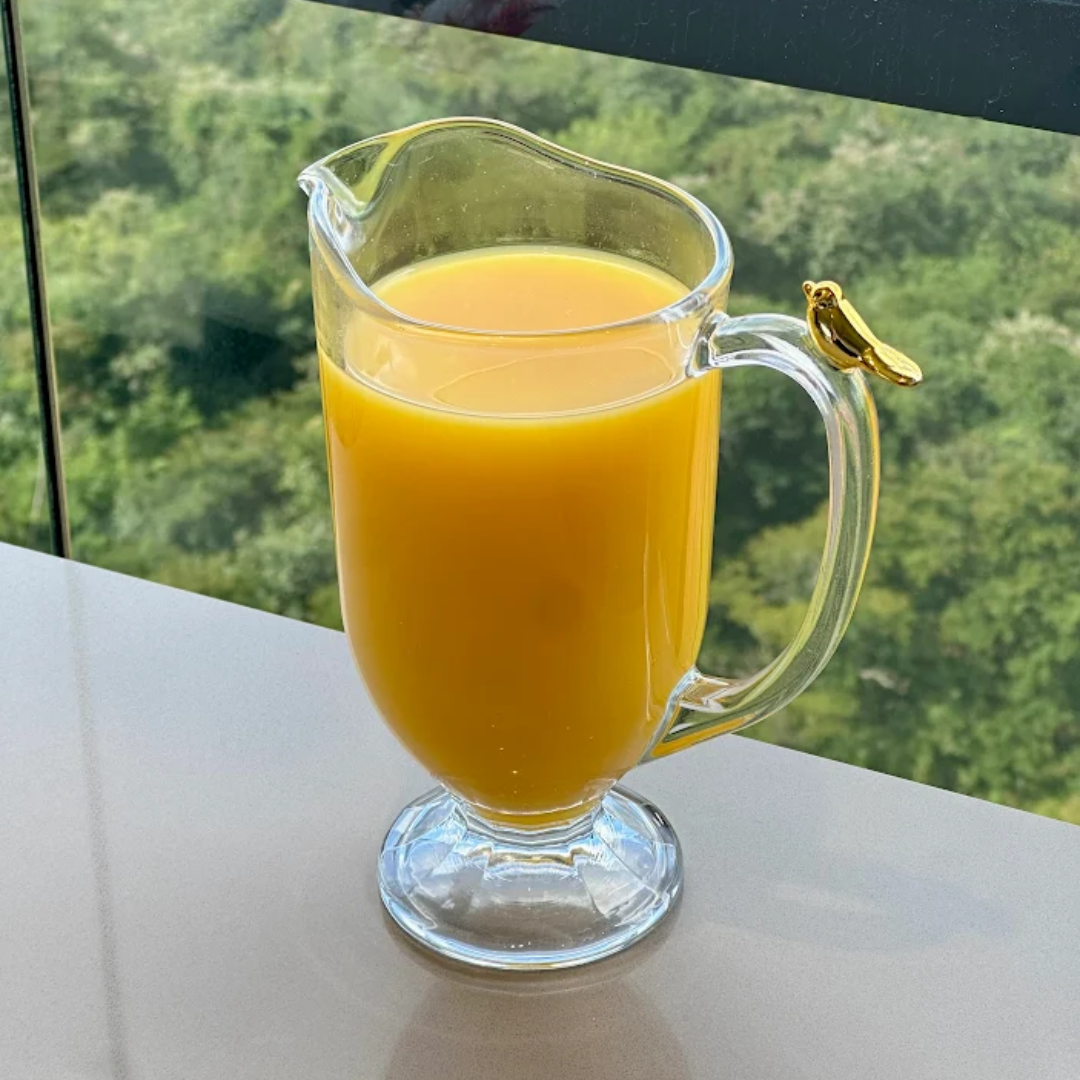 Jarra de vidro com suco natural em ambiente externo com vista de natureza