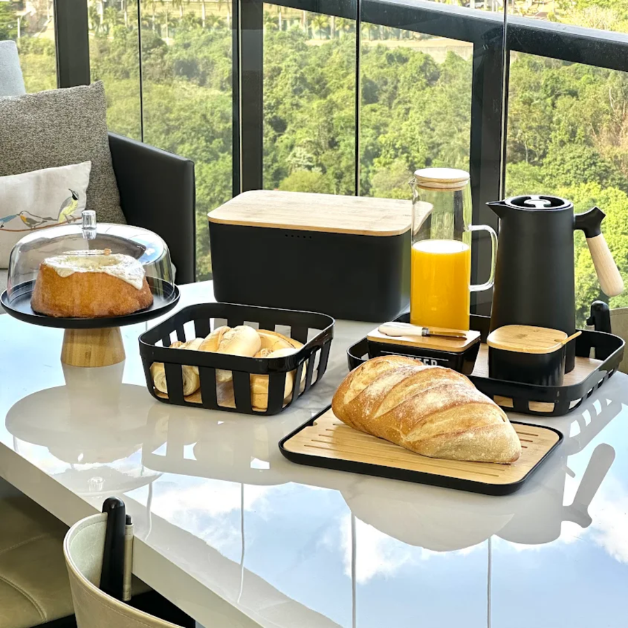 Mesa posta com kit preto e bambu suco e pao em varanda