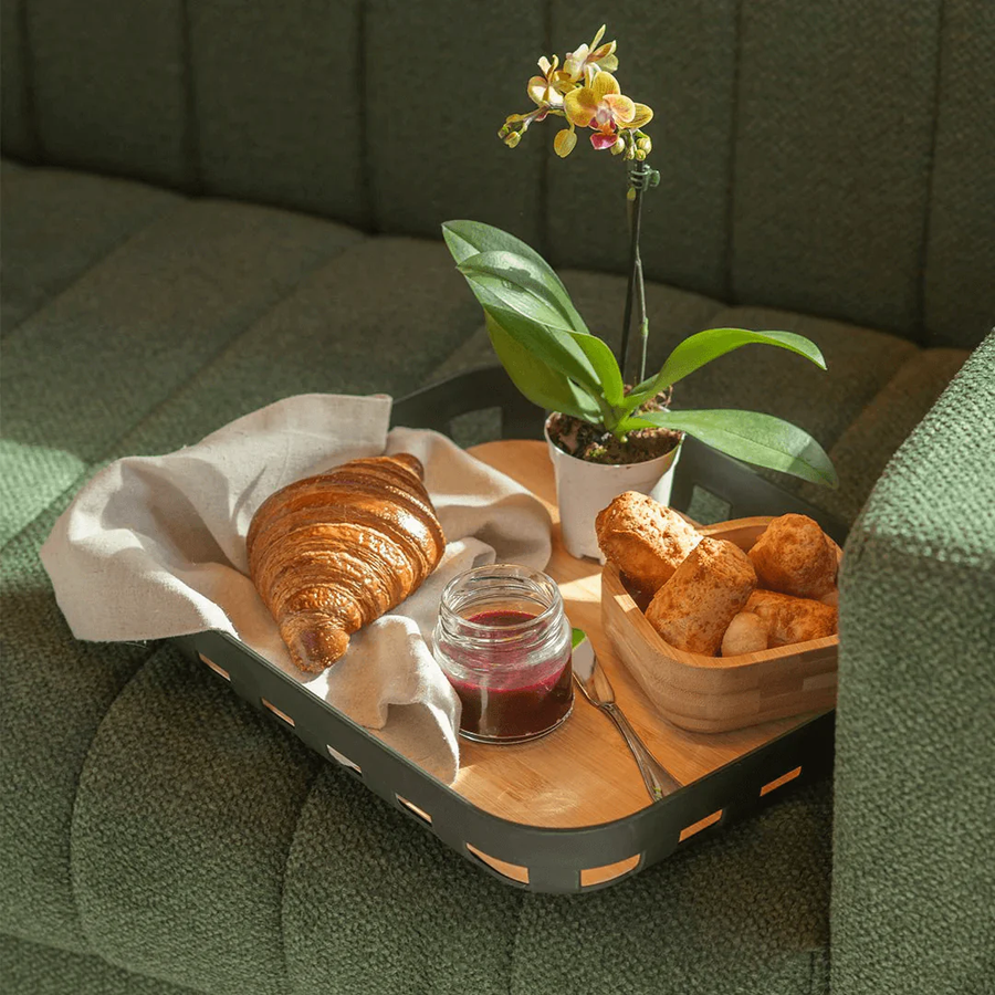 Bandeja retangular preta com bambu croissant e geleia no sofa