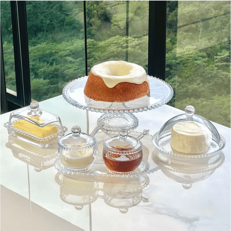 Kit cristal bolinha com bolo, manteigueira, porta-mel e queijo em mesa branca