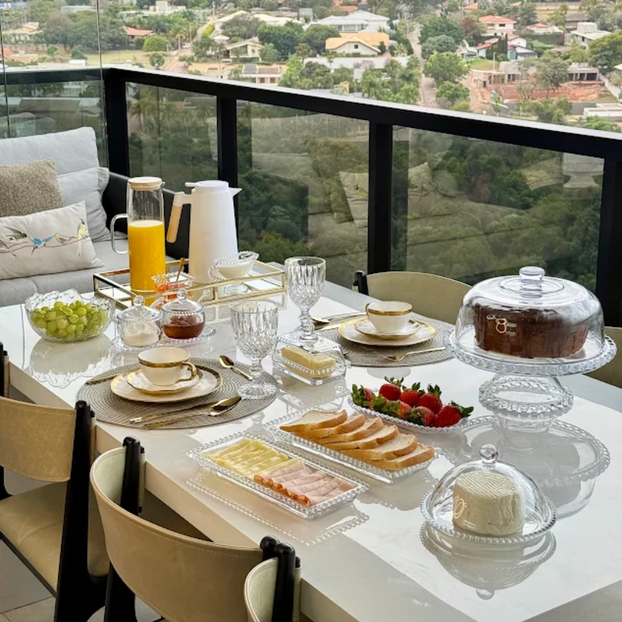 Mesa posta completa para cafe da manha em varanda com vista