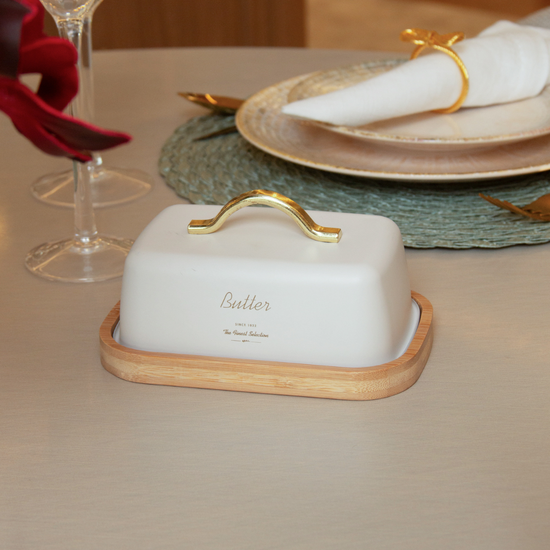 Manteigueira off white com alça dourada em mesa de jantar elegante