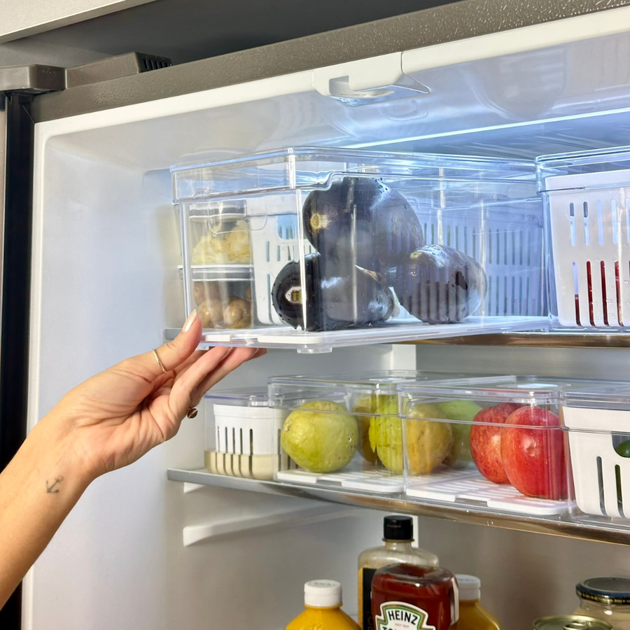 Mão retirando recipiente transparente com furos para conservação de alimentos
