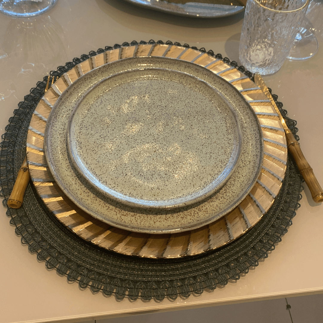 Mesa posta de jantar com pratos, jogo americano e talheres