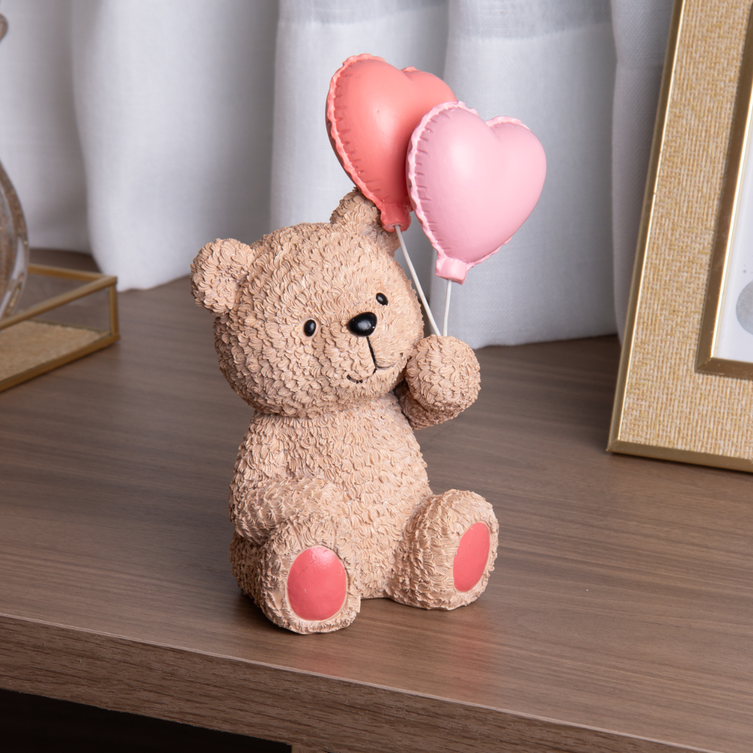 Urso Teddy em resina bege sentado na mesa com balões rosa e coral