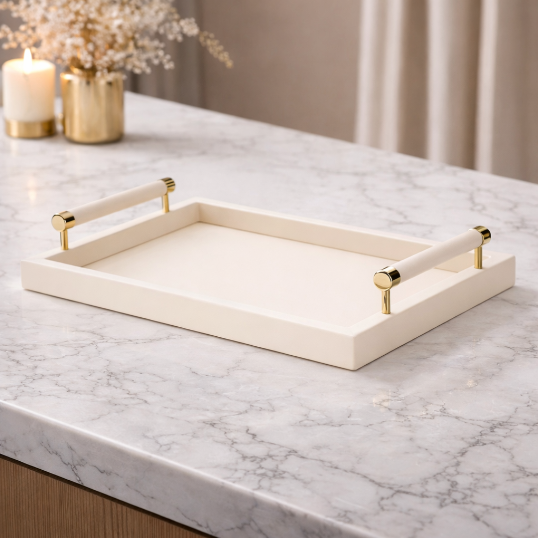 Bandeja bege com alças douradas em mesa de mármore com decoração minimalista