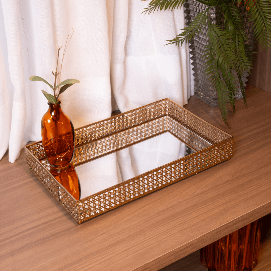 Bandeja de metal dourado com espelho em ambiente de decoração