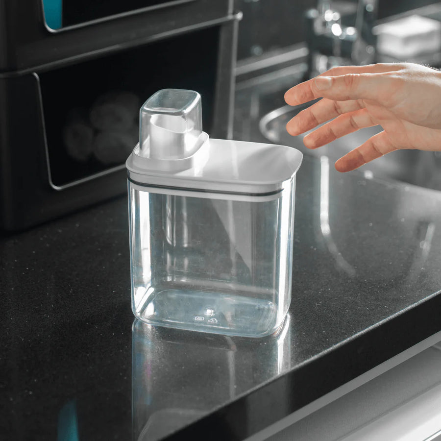 Pote hermético dispenser branco sobre bancada escura de granito