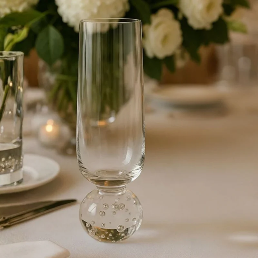 Taça champanhe base esfera em mesa posta com flores e velas