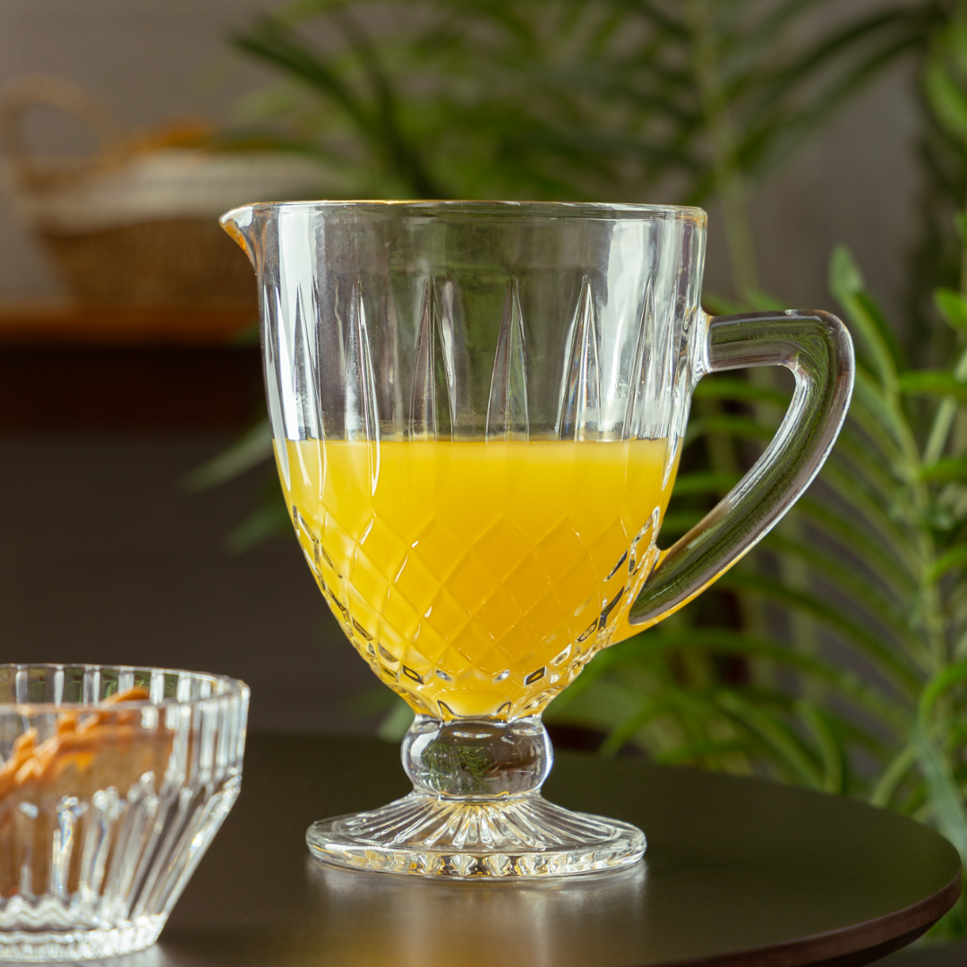 Jarra de vidro Greek com suco amarelo e detalhes em relevo