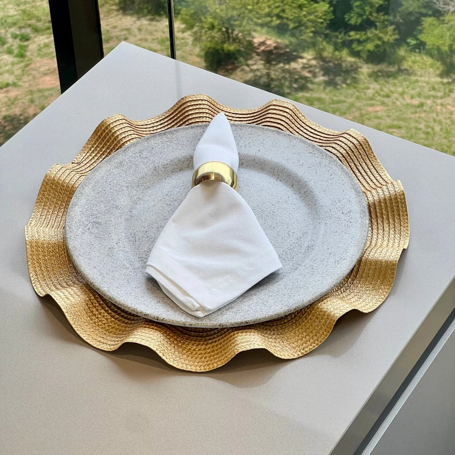 Detalhe do babado ondulado dourado do sousplat em mesa elegante