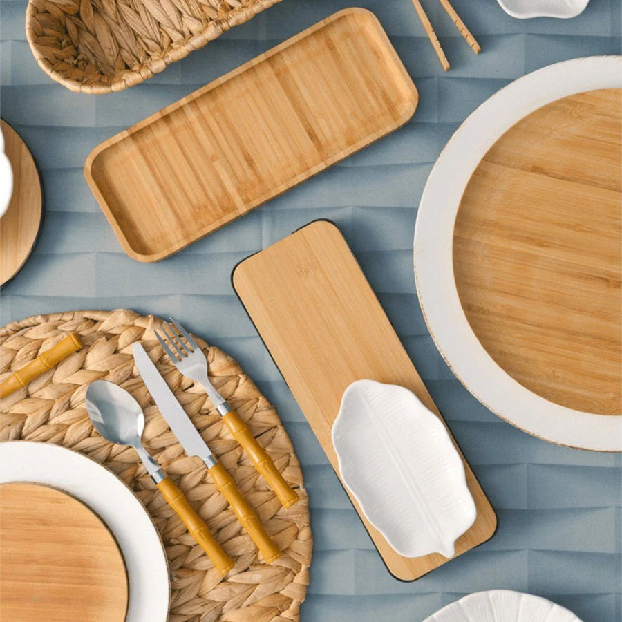 Petisqueiras de bambu entre pratos e utensílios de mesa
