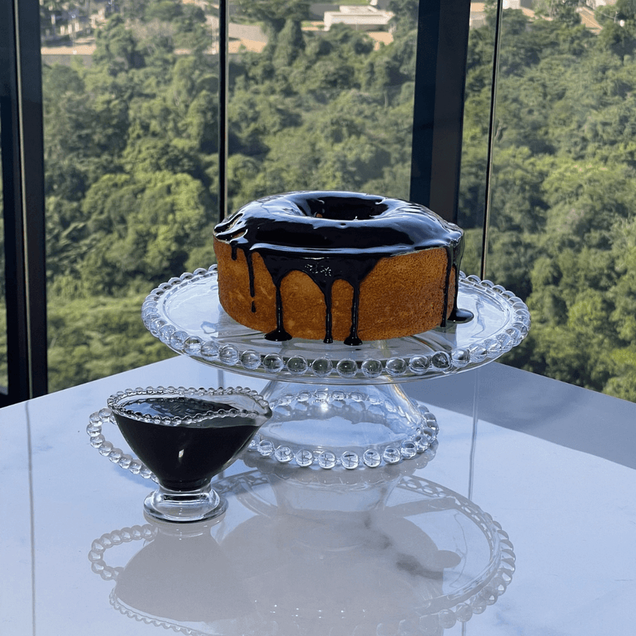 Molheira e boleira de cristal com bolo de chocolate em ambiente gourmet