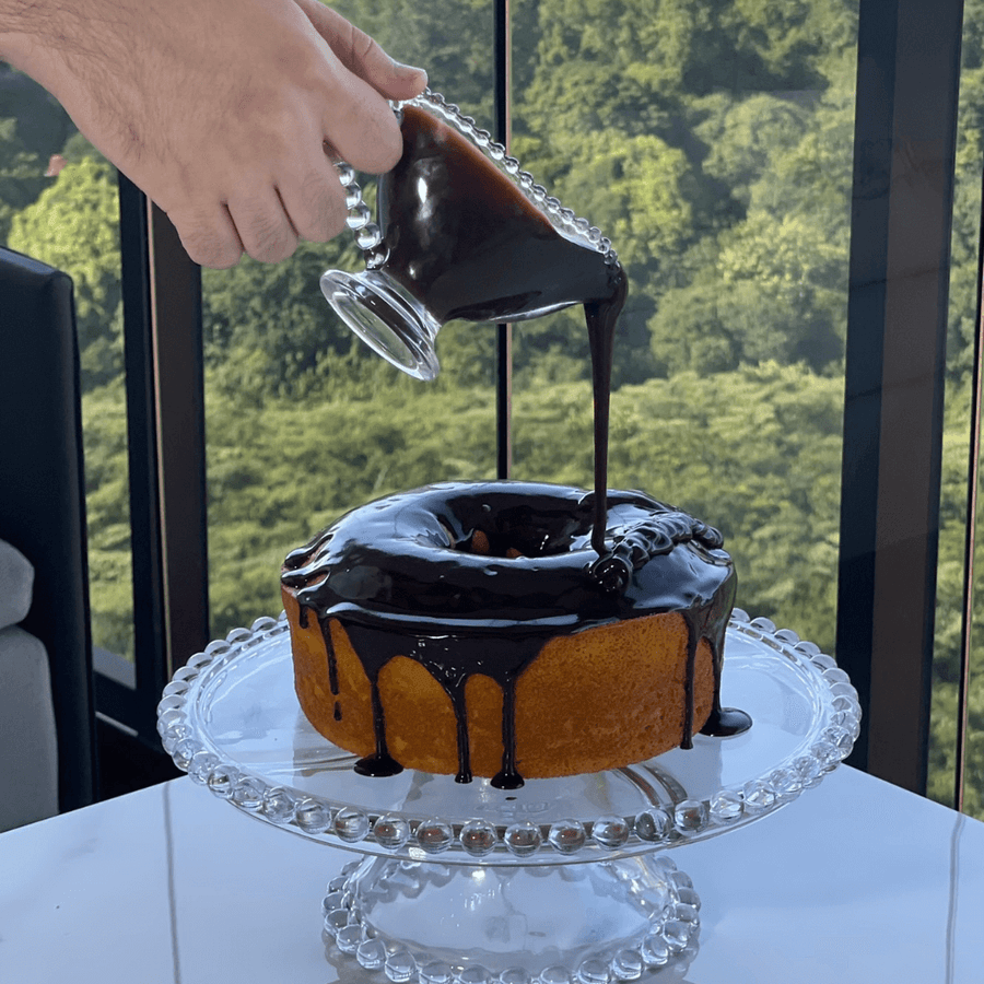 Molheira de vidro derramando cobertura em boleira gourmet Pearl