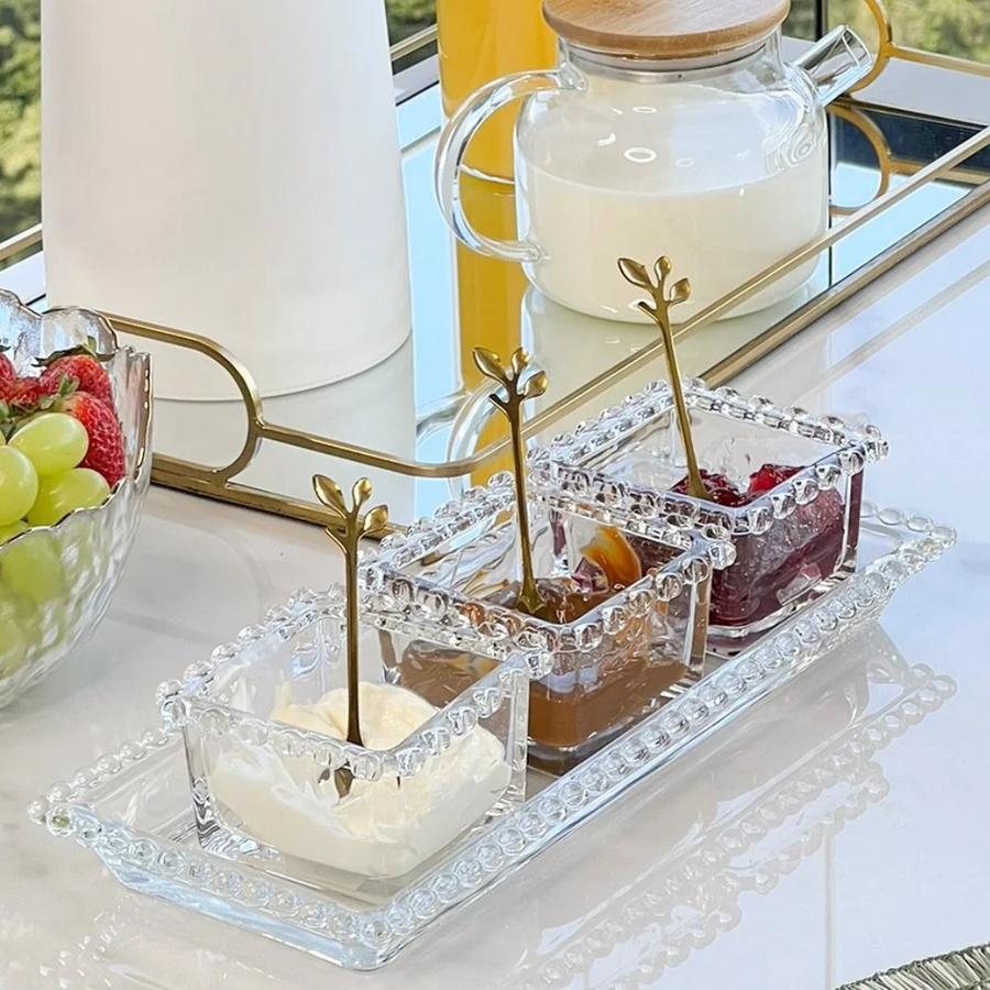 Kit bowls de vidro com colheres douradas em mesa de cafe da manha elegante